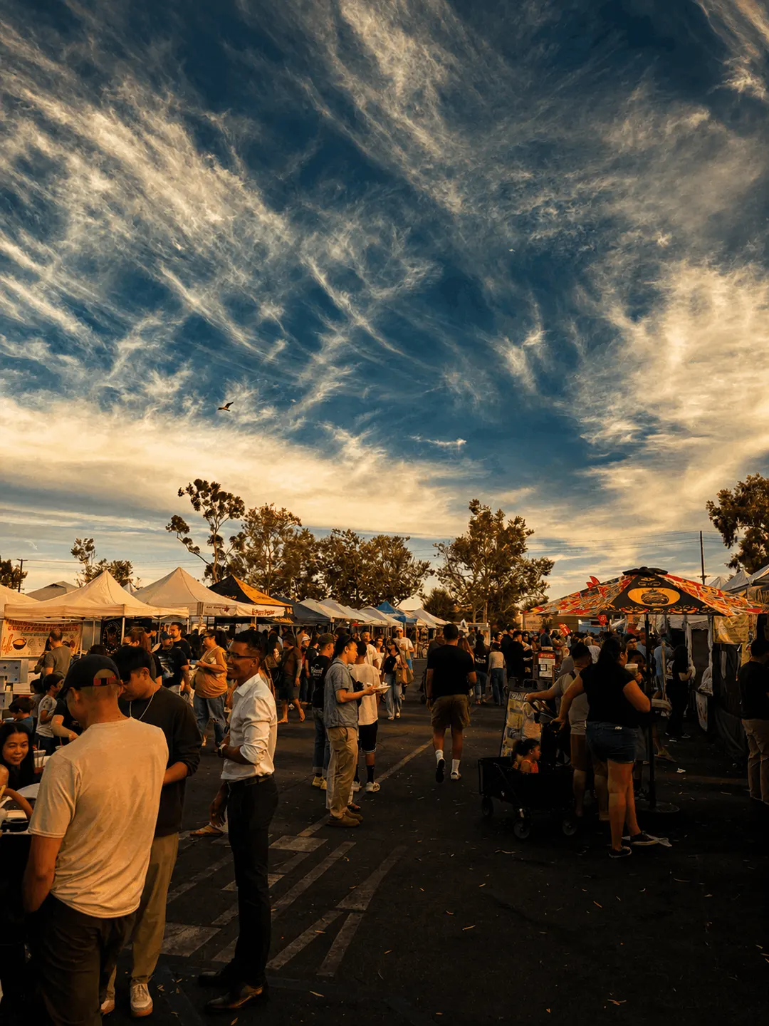 Busy street food market under a dramatic sunset sky, hosted with Vamo Host